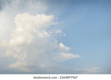 Epic storm cloudscape. White ornamental sunset cumulus clouds. Soft golden sunlight. Clear blue sky. Natural pattern, texture, background, wallpaper, graphic resources, design, copy space - Powered by Shutterstock