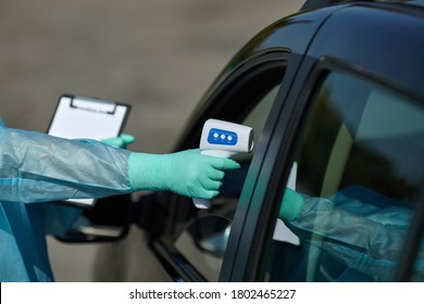 Epidemic concept COVID-19. Coronavirus Test Station. Medical worker in full protective checks the temperature at a COVID-19 drive-thru test site. Checking children before school.  - Powered by Shutterstock