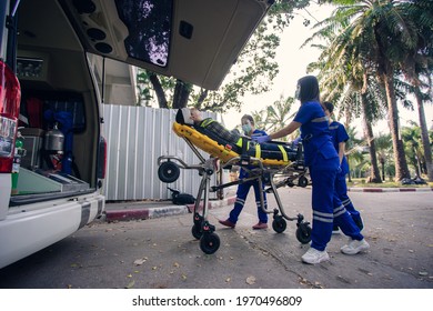 In The Epidemic Crisis Coronavirus (COVID-19), EMS Team Of Paramedic React Quick To Provide Medical Help To Injured Patient Accident At Site Work And Transfer Him In Ambulance On A Stretcher.