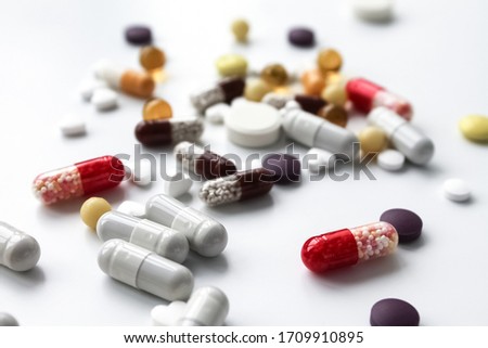 Epidemic / disease. A pile of pills is scattered on the table. Elevated temperature.