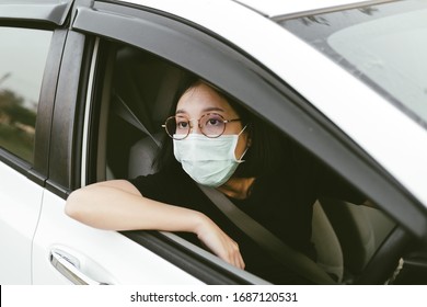 Epidemic outbreak. Female asian driving a car through checkpoint and wearing surgery mask. - Powered by Shutterstock