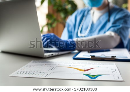 Epidemiologist doctor working on laptop computer,analyzing graphs  charts,COVID-19 Coronavirus global pandemic crisis outbreak,mortality rate death toll statistics,research data comparison,WHO info