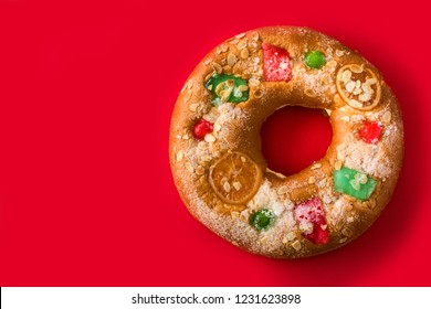 Epiphany cake "Roscon de Reyes" on red background. Top view. Copyspace