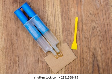 Epoxy Glue in syringe,a+b glue on wood table. - Shutterstock ID 2131558495