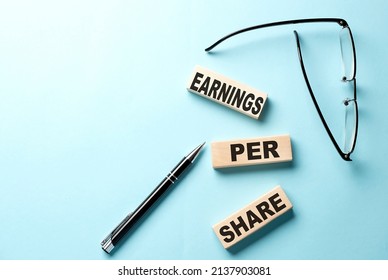 EPS - Earnings Per Share text on wooden block ,blue background