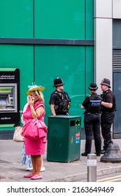 Epson Surrey, London UK, June 03 2022, Woman Dressed In Pink Dress Using Mobile Phone With Police Officers In Background