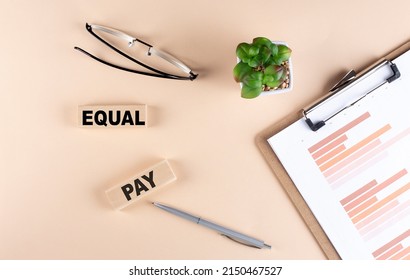 EQUAL PAY text on a wooden block with chart and glasses, business concept