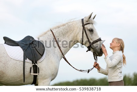 Equestrian rider girl with a white arabian horse.