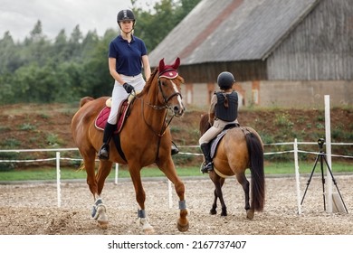 Equestrian sport -young girl rides on horse and little girl rides on pony in during training. - Powered by Shutterstock