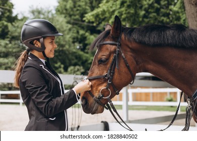 Equestrian sport - a young girl is standing near horse - Powered by Shutterstock