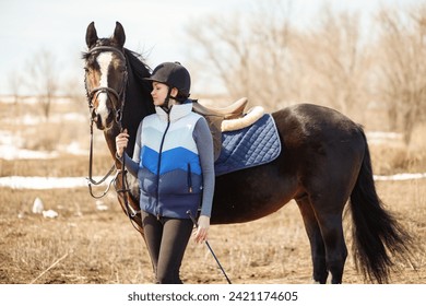 Equestrian sportsman with a horse on the spring field - Powered by Shutterstock