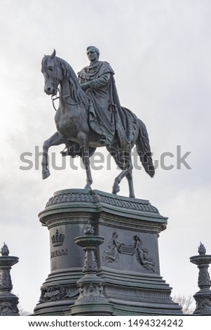 Equestrian statue of Saxon King Johann (1889) in front of Semperoper opera house on Theatre square in Dresden. Equestrian statue of King, on a base - bronze reliefs on all sides. Dresden, Germany.