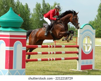 Equestrian Woman Jump Obstacle On Bay Horse In Show Jumping