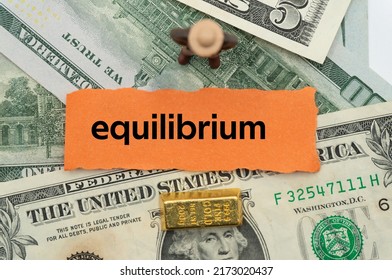 Equilibrium.The Word Is Written On A Slip Of Paper,on Colored Background. Professional Terms Of Finance, Business Words, Economic Phrases. Concept Of Economy.