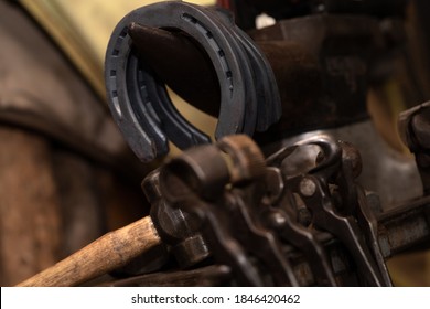 Equipment in blacksmith shop with horseshoes in background  - Powered by Shutterstock