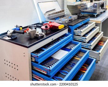 Equipment for car mechanic. Metal carts with tools. Trolleys with tools in workshop. Workplace of mechanic. Equipment for locksmith work. Metal cabinets with drawers. Sale of equipment for mechanic.