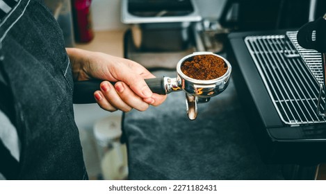 Equipment of coffee maker coffee portafilter filled with finely ground coffee In the hands of the barista getting ready to make coffee. - Powered by Shutterstock