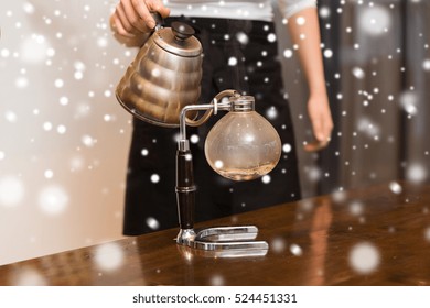 Equipment, Coffee Shop, People And Technology Concept - Close Up Of Woman With Pot Pouring Hot Water To Coffeemaker Filter At Cafe Bar Or Restaurant Kitchen Over Snow