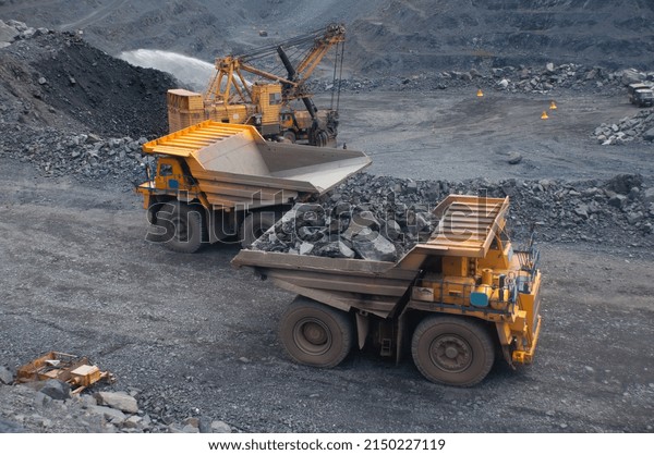 equipment (excavators,\
dump trucks, drilling rigs) moves along the roads of the iron ore\
quarry. At the bottom of the quarry, explosives for a technological\
explosion were laid.