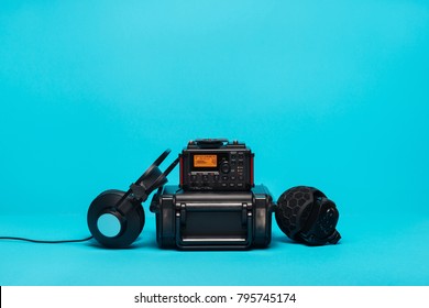 Equipment For Field Audio Recording On Blue Background. Microphone, Recorder, Headphones And Case.