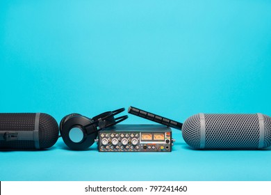 Equipment For Field Audio Recording On Blue Background. Windshield, Shotgun Microphone, Mixer And Headphones