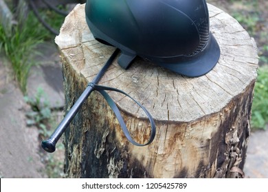 Equipment For Horse Riding: Helmet And Whip On The Wood Close Up