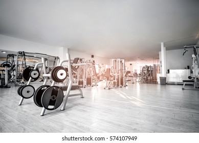 Equipment And Machines At The Empty Modern Gym Room. Fitness Center. Toned Image.