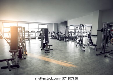 Equipment And Machines At The Empty Modern Gym Room. Fitness Center. Toned image.