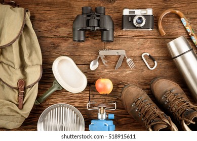 Equipment for mountaineering and hiking on wooden background