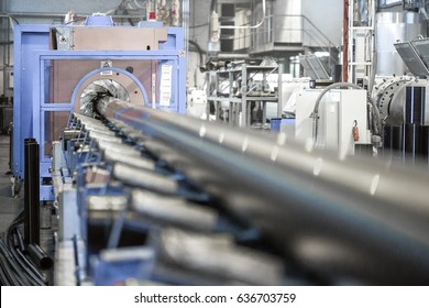 Equipment Of A Plant Producing Plastic Pipes. Conveyor In The Industrial Factory For The Production Of Plastic Pipes.