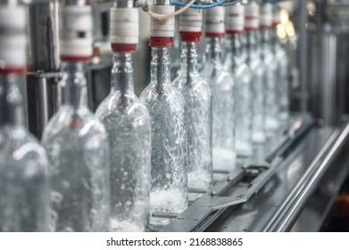 Equipment Pours Vodka Into Glass Bottles On Production Line