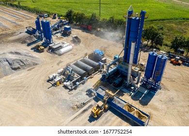 Equipment for production of asphalt, cement and concrete. Concrete plant. High tower of an asphalt plant. Harmful production. A mixture of bitumen and gravel, a mix machine. Aerial view.