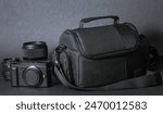 Equipment of a professional photographer. Photo bag with camera and lens on black background