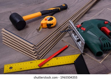 Equipment Or Tools To Install Laminate Floor, Rubber Hammer, Electric Jig Saw, Pencil And Metre. Selective Focus. 