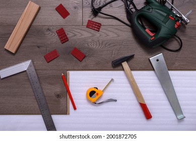 Equipment Or Tools To Install Laminate Floor, Hammer, Electric Jig Saw, Pencil, Angle Ruler, Spacers And Metre. Selective Focus.