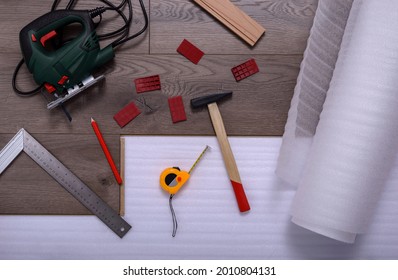 Equipment Or Tools To Install Laminate Floor, Hammer, Electric Jig Saw, Pencil, Angle Ruler, Spacers And Metre. Selective Focus.