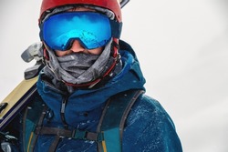Esquiador Equipado Con Esquís En El Hombro Y Mirando Directamente A La Cámara, Retrato. Hombre Con Equipo De Invierno En Las Montañas En Una Estación De Esquí