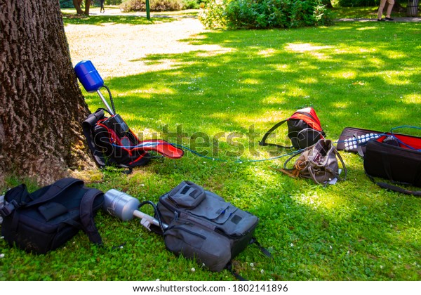 Equopment of a news crew in a park left on\
grass while taking\
interview