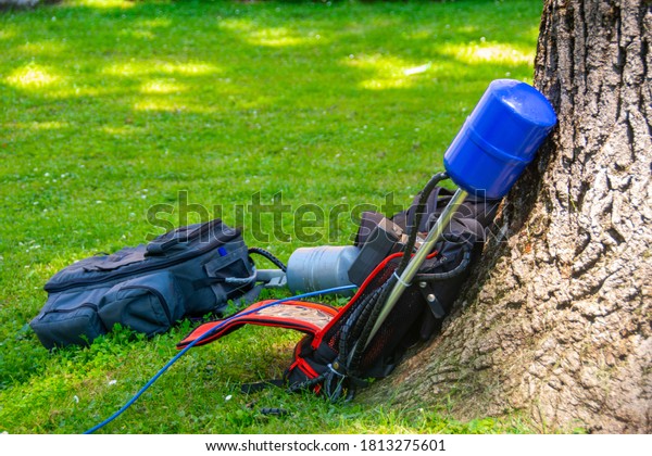 Equopment of a news crew in a park\
left on grass while taking interview ready for live\
broadcasting