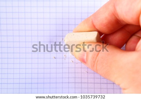 Eraser in hand erasing on a sheet in a cage