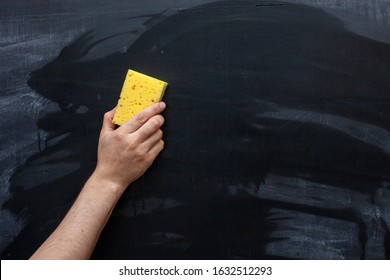 Erasing The Chalkboard. Hand Wipes The Chalk From The Chalkboard