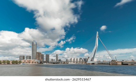 Erasmus Bridge timelapse hyperlapse, spanning the Maas River in Rotterdam, Netherlands. Holland's largest cable-stayed bascule bridge with skyscrapers, boats and dramatic cloudy sky backdrop