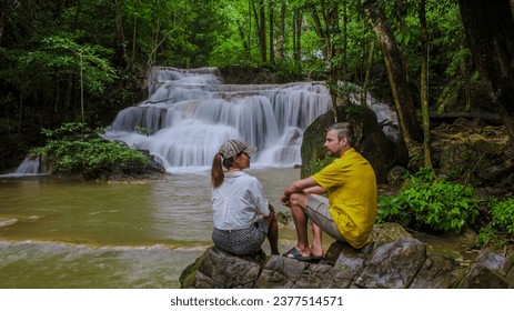 Erawan Waterfall Thailand, a beautiful deep forest waterfall in Thailand. Erawan Waterfall in National Park. a couple of men and women on a trip visiting nature with forest and waterfalls - Powered by Shutterstock