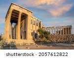 Erechtheion Temple (Erechtheum) with the Caryatids at the archaeological site of Acropolis in Athens, Greece. Parthenon Temple in the background. Panoramic view, colorful clouds, golden light. sky