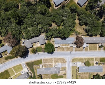 erial view of a residential complex or rustic cabins nestled inside a dense green pine forest