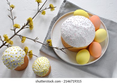 Erkhu.
Easter Cake On A White Plate With Easter Eggs. Nearby On The Table Are Two Smaller Easter Cakes And A Flowering Branch. View From Above