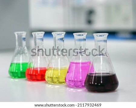 The Erlenmeyer or Conical flask on bench laboratory, with colorful solvent solution from titration experiment, acidity, alkalinity, and total hardness analysis compounding in wastewater sample.