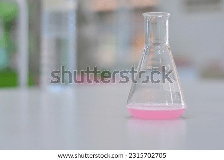 
The Erlenmeyer flask has a distinctive shape with a flat, triangular base, a cylindrical neck, and a conical body. The neck of the flask is narrower than the body, and it often includes a small openi