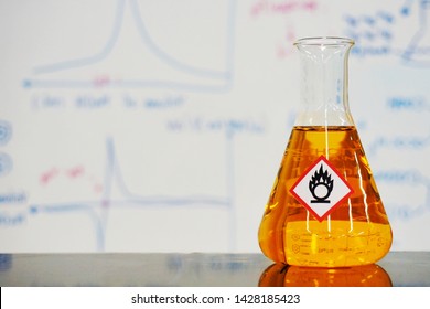 Erlenmeyer Flask With Orange Liquid And Chemical Hazard Warning Symbols Labels (oxidizing Agent Sign) On Whiteboard With Chemical Learning Background.