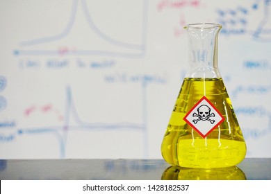 Erlenmeyer Flask With Yellow Liquid And Chemical Hazard Warning Symbols Labels (acute Toxicity Symbol) On Whiteboard With Chemical Learning Background.